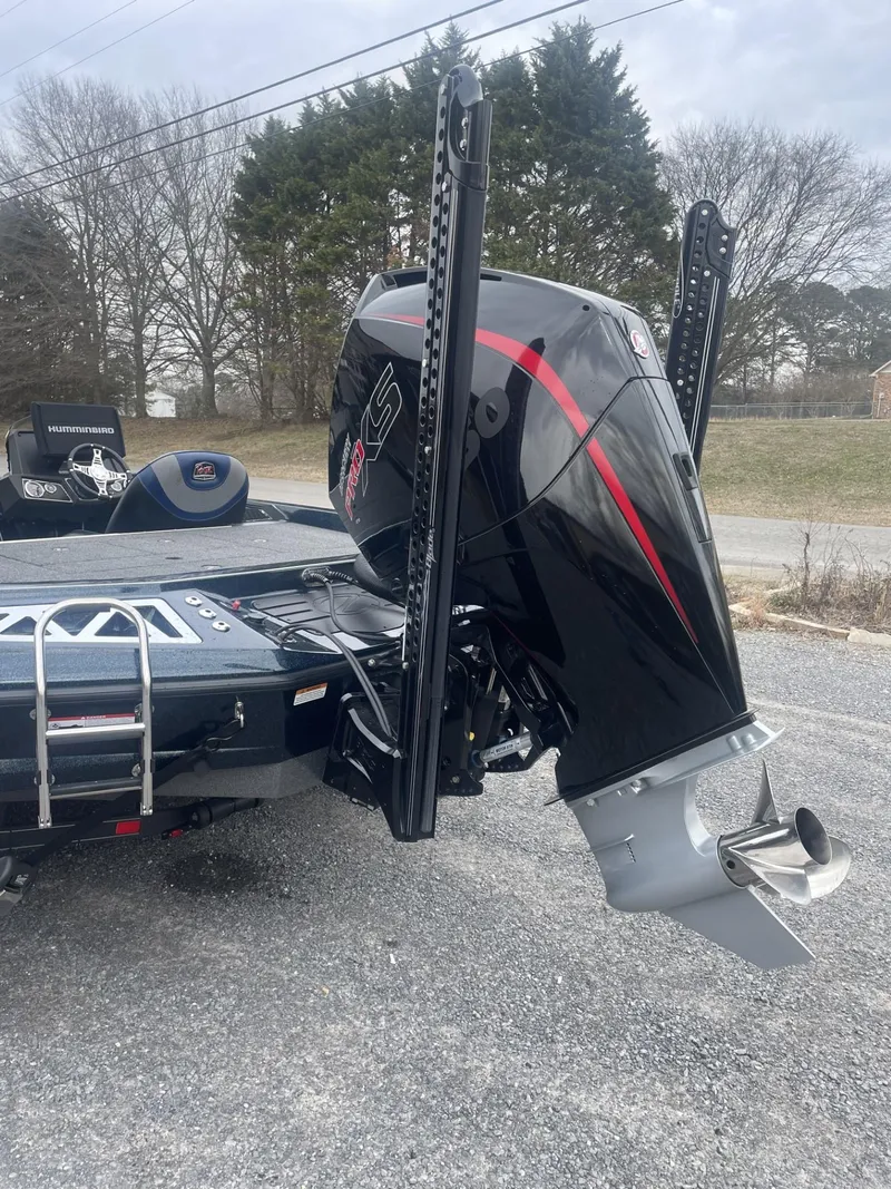 Slide: The Image of 2021 Ranger Z521L boat with a powerful outboard motor, parked on a gravel surface. - 4