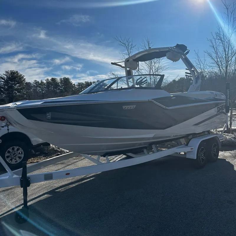 Slide: The Image of 2023 Supreme ZS232 boat on a trailer under a clear blue sky. - 0