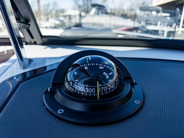 Slide: The Image of Close-up of a compass on the 2024 Monterey 258 SS boat dashboard. - 30