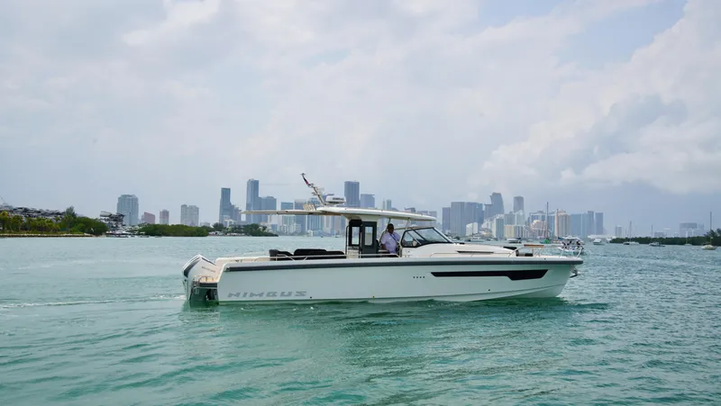 Slide: The Image of 2024 Nimbus Tender 11 #258 cruising in a city harbor with skyline backdrop. - 1