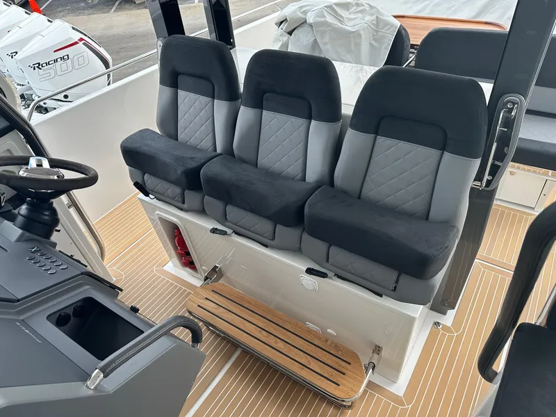 Slide: The Image of 2024 Nimbus Tender 11 #258 interior seating with black and gray cushioned seats. - 10