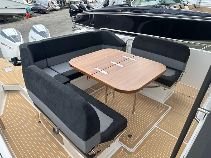 Slide: The Image of 2024 Nimbus Tender 11 #258 boat with seating area and wooden table. - 14