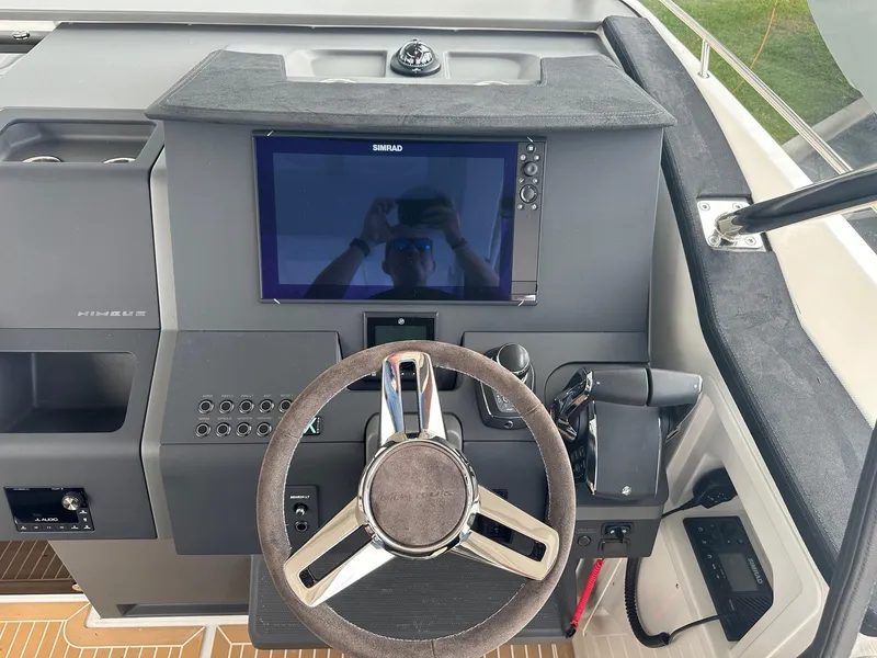 Slide: The Image of 2024 Nimbus Tender 11 #258 boat dashboard with steering wheel and navigation screen. - 18