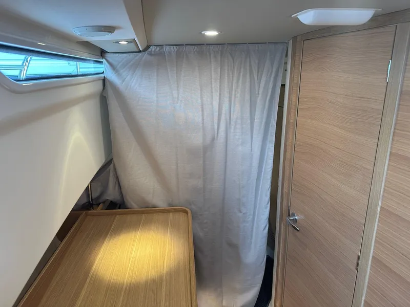 Slide: The Image of Interior cabin of 2024 Nimbus Tender 11 #258 with wooden table and curtain. - 22
