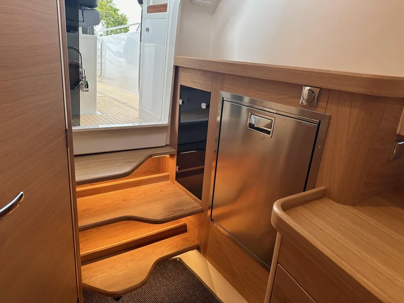 Slide: The Image of Interior of 2024 Nimbus Tender 11 #258, featuring wooden steps and stainless steel appliances. - 32