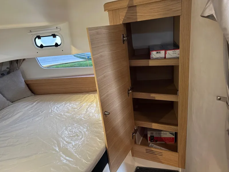 Slide: The Image of Interior of 2024 Nimbus Tender 11 #258 with bed and open wooden cabinet. - 34