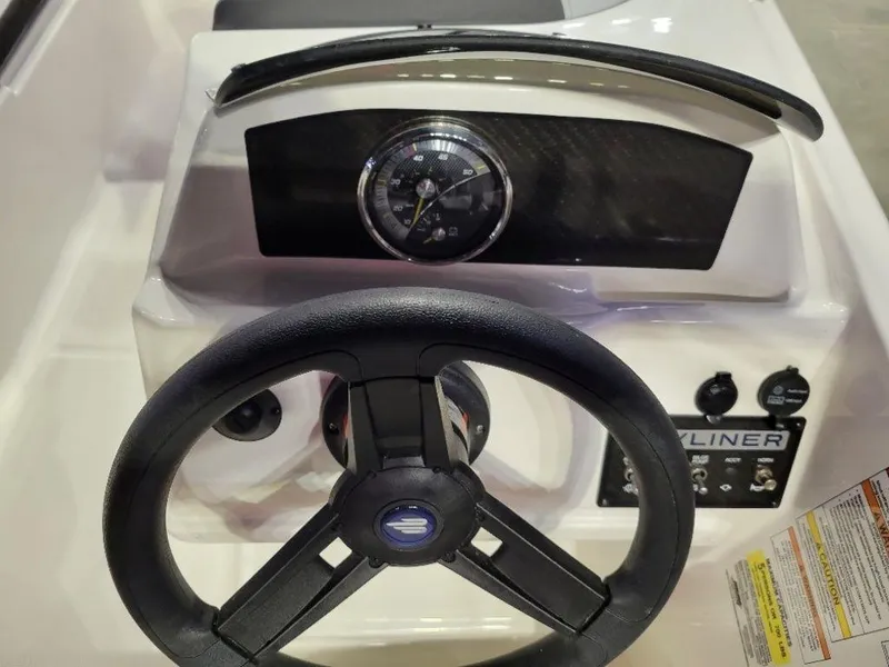 Slide: The Image of 2024 Bayliner M15 boat dashboard with steering wheel and instrument panel. - 2