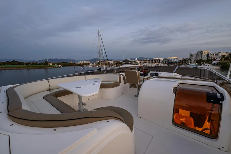 Slide: The Image of 2002 Viking Princess 72 SportCruiser yacht deck with seating and table at sunset. - 22