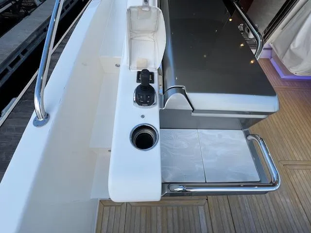 Slide: The Image of 2020 Riviera 5400 Sport Yacht deck with control panel and seating area. - 22