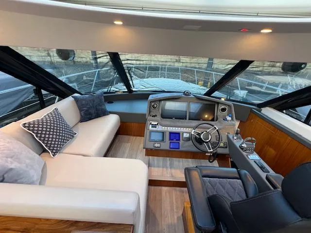 Slide: The Image of 2020 Riviera 5400 Sport Yacht interior with helm, seating, and modern controls. - 38