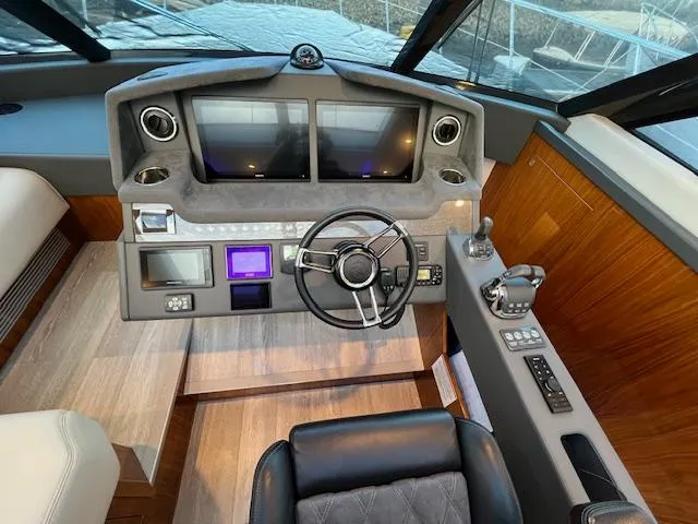 Slide: The Image of 2020 Riviera 5400 Sport Yacht helm with modern controls and dual screens. - 40