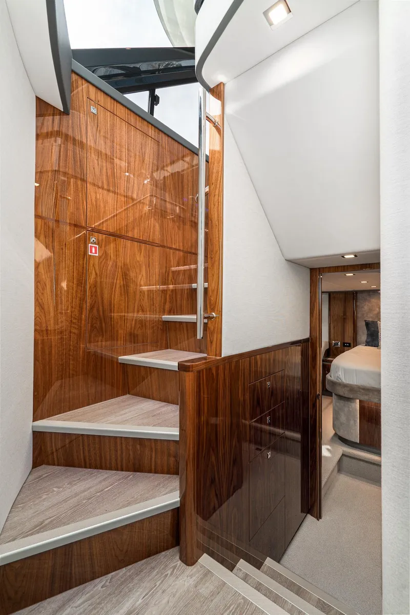 Slide: The Image of Interior staircase of 2020 Riviera 5400 Sport Yacht with polished wood finish. - 44
