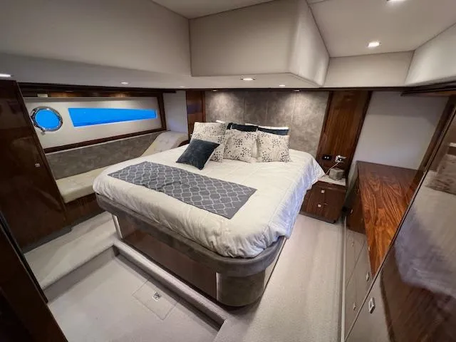 Slide: The Image of Luxurious bedroom interior of 2020 Riviera 5400 Sport Yacht with elegant bedding and wood accents. - 46