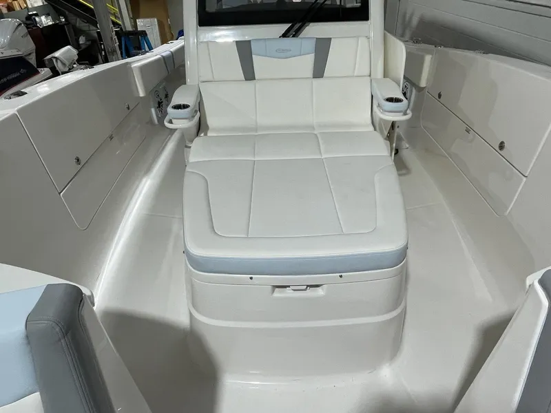 Slide: The Image of 2023 Robalo R360 Center Console boat interior with white seating and storage compartments. - 5