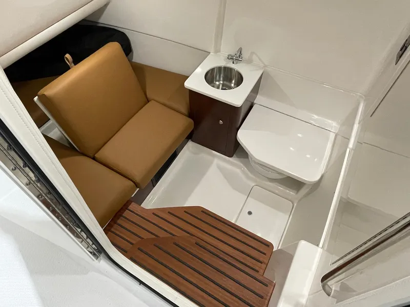 Slide: The Image of 2023 Robalo R360 Center Console cabin with seating, sink, and toilet. - 7