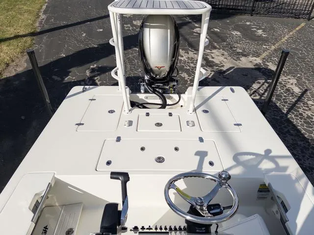 Slide: The Image of 2024 Hewes Redfisher 18 boat with steering wheel and motor, viewed from above. - 11