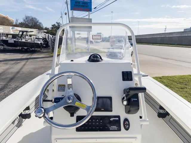 Slide: The Image of 2024 Hewes Redfisher 18 boat console with steering wheel and controls. - 18