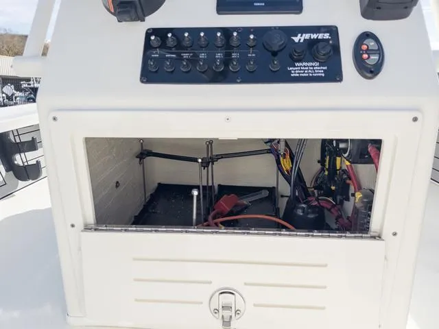 Slide: The Image of 2024 Hewes Redfisher 18 boat console with open storage compartment and control panel. - 19