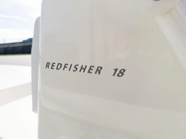 Slide: The Image of 2024 Hewes Redfisher 18 boat logo on white surface. - 30