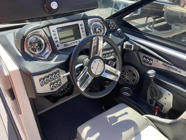 Slide: The Image of 2016 Supra SA 400 boat dashboard with steering wheel and control panel. - 14