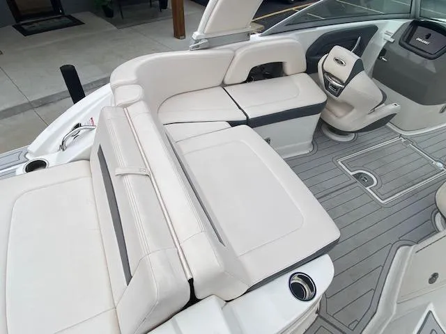Slide: The Image of 2018 Chaparral 224 Sunesta boat interior with white leather seating and gray flooring. - 16