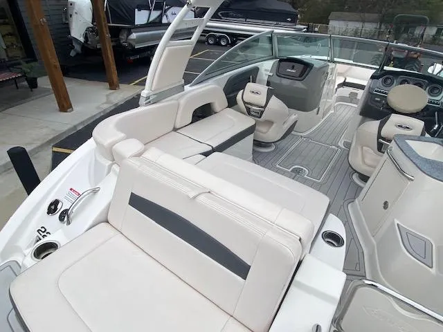 Slide: The Image of 2018 Chaparral 224 Sunesta boat interior with white and gray seating, dashboard, and steering wheel. - 19
