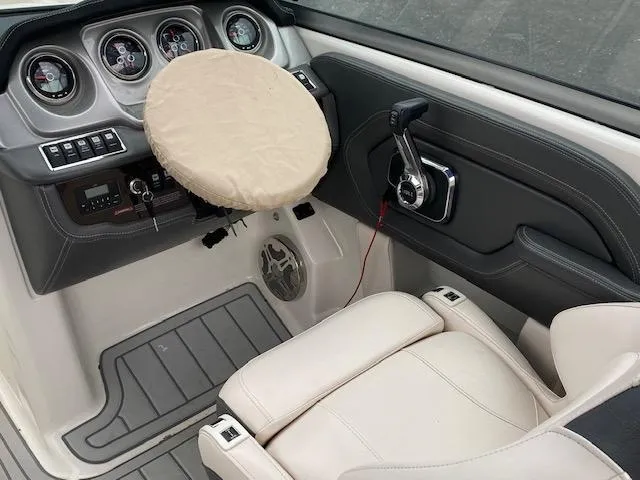 Slide: The Image of 2018 Chaparral 224 Sunesta boat cockpit with covered steering wheel and control panel. - 26