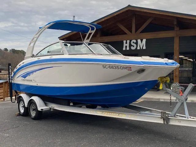 Slide: The Image of 2018 Chaparral 224 Sunesta boat on a trailer outside a wooden building. - 7