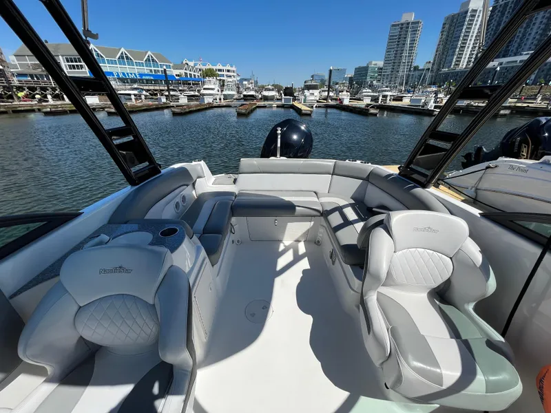 Slide: The Image of 2021 NauticStar 243DC Sport Deck boat interior at marina, modern seating, waterfront view. - 19