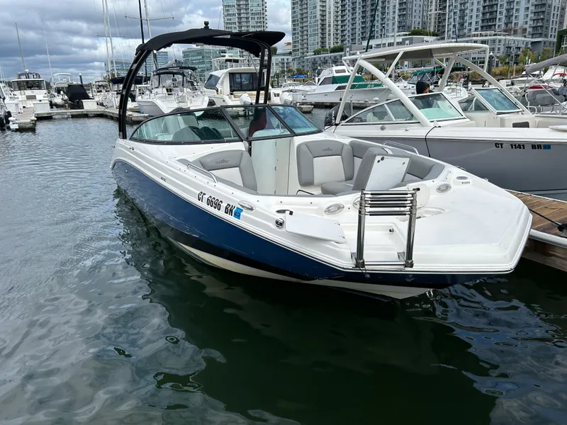 Slide: The Image of 2021 NauticStar 243DC Sport Deck boat docked in marina, surrounded by other vessels. - 20