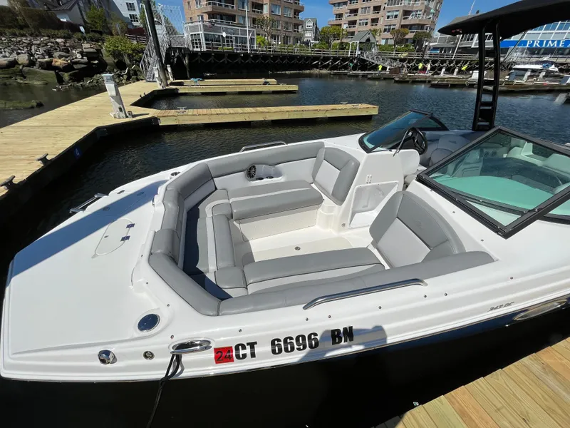 Slide: The Image of 2021 NauticStar 243DC Sport Deck boat docked in marina, featuring spacious seating. - 6
