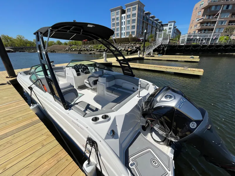 Slide: The Image of 2021 NauticStar 243DC Sport Deck boat docked in urban marina setting. - 8