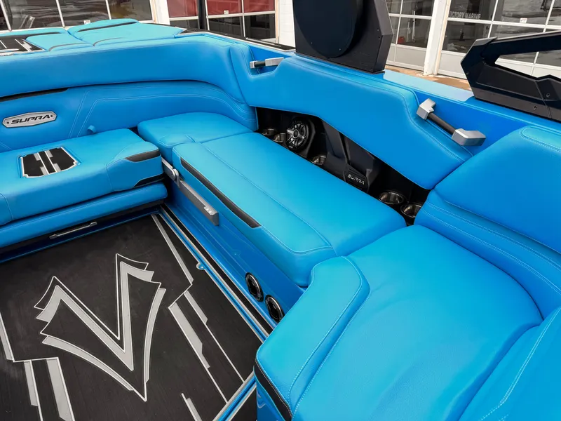 Slide: The Image of 2021 Supra SR boat interior with blue leather seats and black flooring. - 12