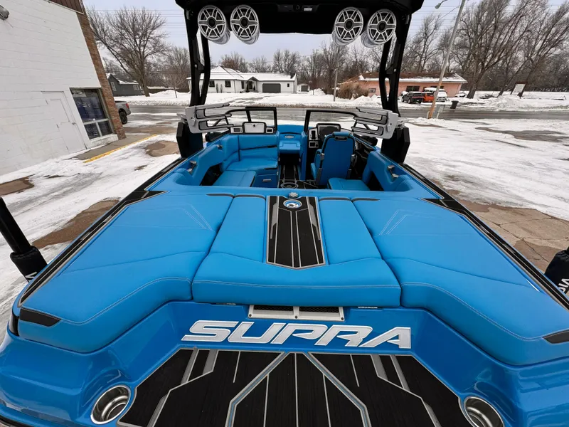 Slide: The Image of 2021 Supra SR boat with blue interior, parked in snowy outdoor setting. - 18