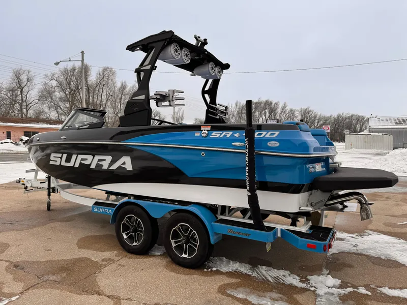 Slide: The Image of 2021 Supra SR boat in blue and black on a matching trailer. - 4