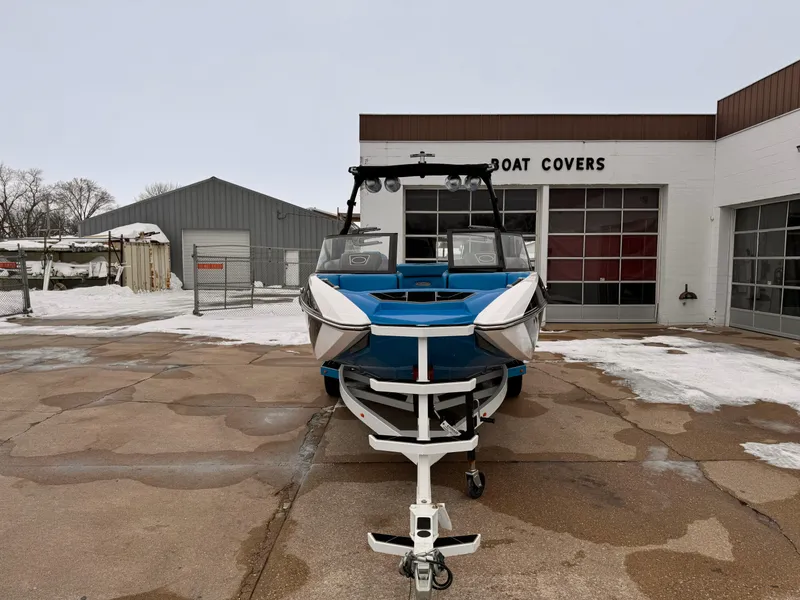 Slide: The Image of 2021 Supra SR boat in front of a boat covers shop during winter. - 6