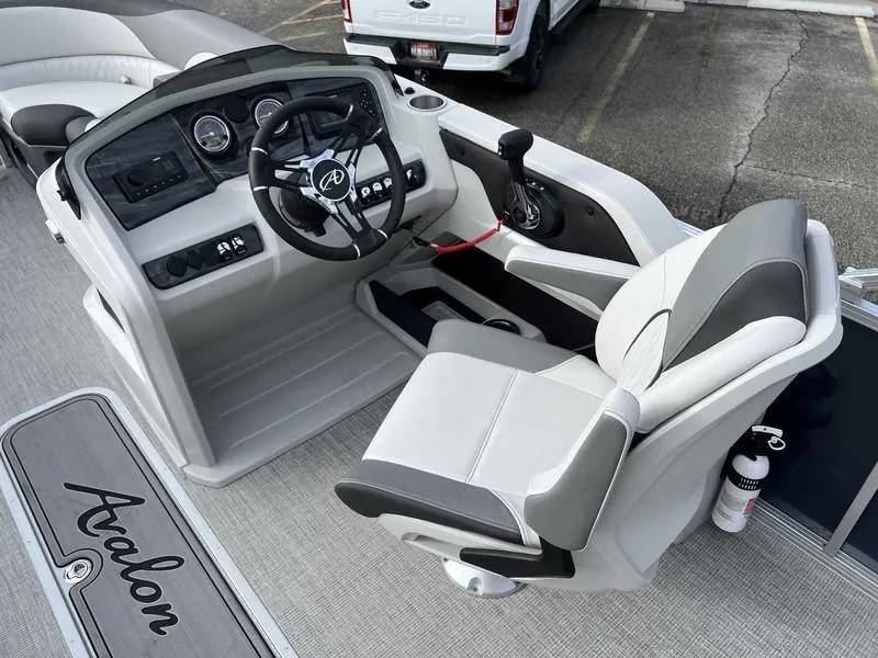 Slide: The Image of 2024 Avalon 2385 25 LSZ Fish RF boat cockpit with steering wheel and captain's chair. - 13