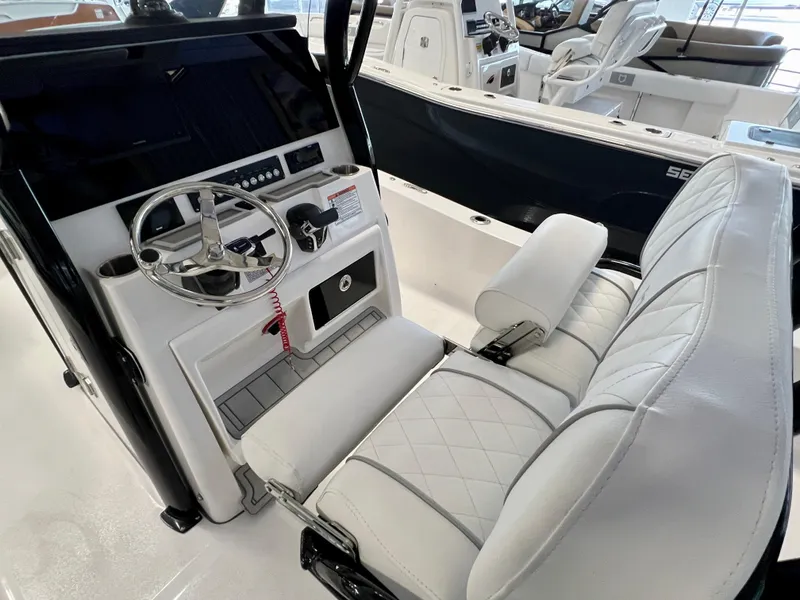 Slide: The Image of 2024 Sea Fox 251 Bay boat interior with steering wheel and cushioned seating. - 6
