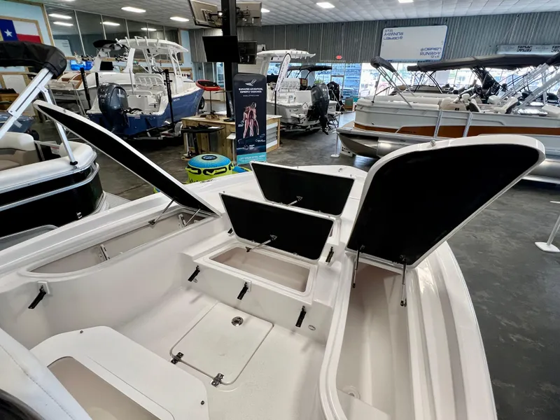 Slide: The Image of 2024 Sea Fox 251 Bay boat interior at a showroom with open storage compartments. - 8
