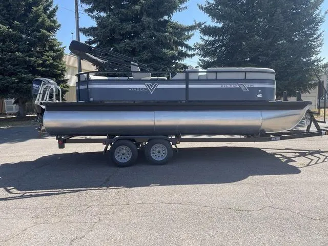 Slide: The Image of 2023 Viaggio DM20C pontoon boat on a trailer, parked outdoors. - 6