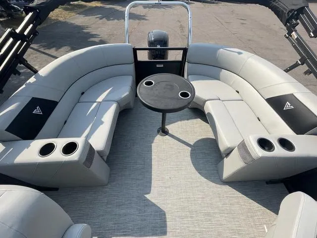 Slide: The Image of 2023 Viaggio DM18U pontoon boat interior with gray seating and a central table. - 11