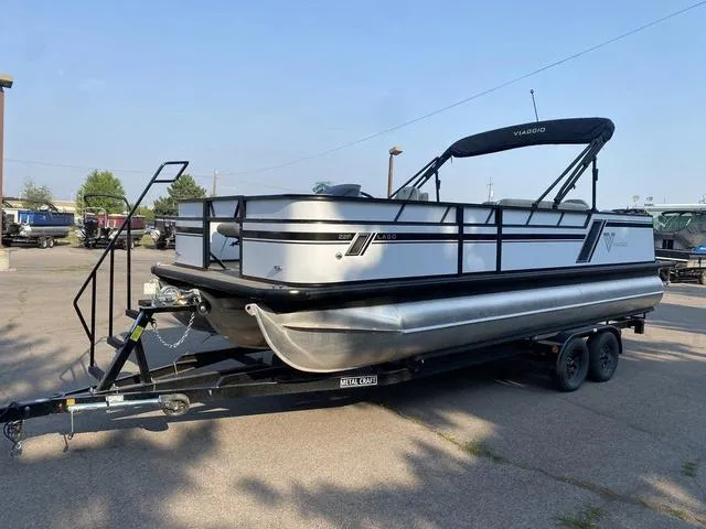 Slide: The Image of 2023 Viaggio LAGO 22F pontoon boat on a trailer in a parking lot. - 1
