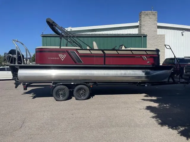 Slide: The Image of 2023 Viaggio L22T pontoon boat on a trailer, parked outside a building. - 5