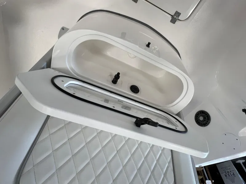 Slide: The Image of 2024 Sea Fox 231 Bay boat interior storage compartment with white quilted upholstery. - 11