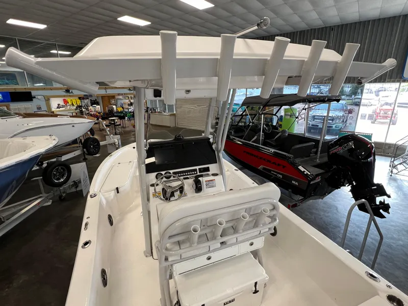 Slide: The Image of 2024 Sea Fox 231 Bay boat interior with rod holders and console in showroom. - 6