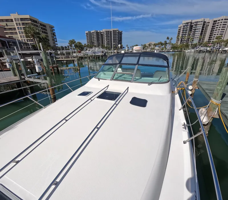 Slide: The Image of 1995 Sea Ray 370 Sundancer docked at marina with waterfront buildings in background. - 15