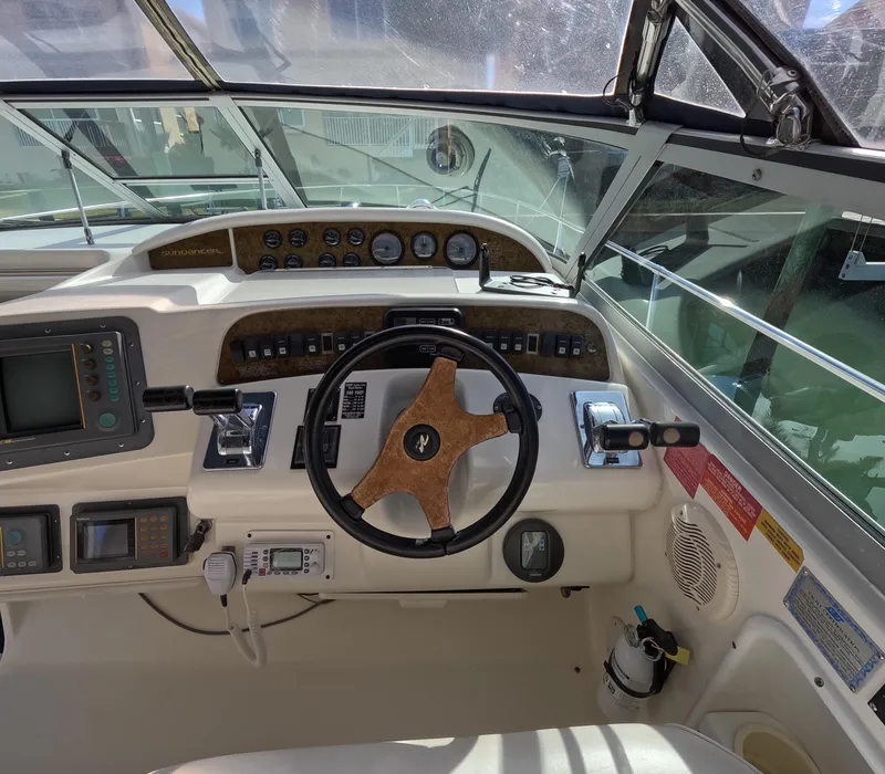 Slide: The Image of 1995 Sea Ray 370 Sundancer helm with steering wheel, gauges, and navigation equipment. - 2