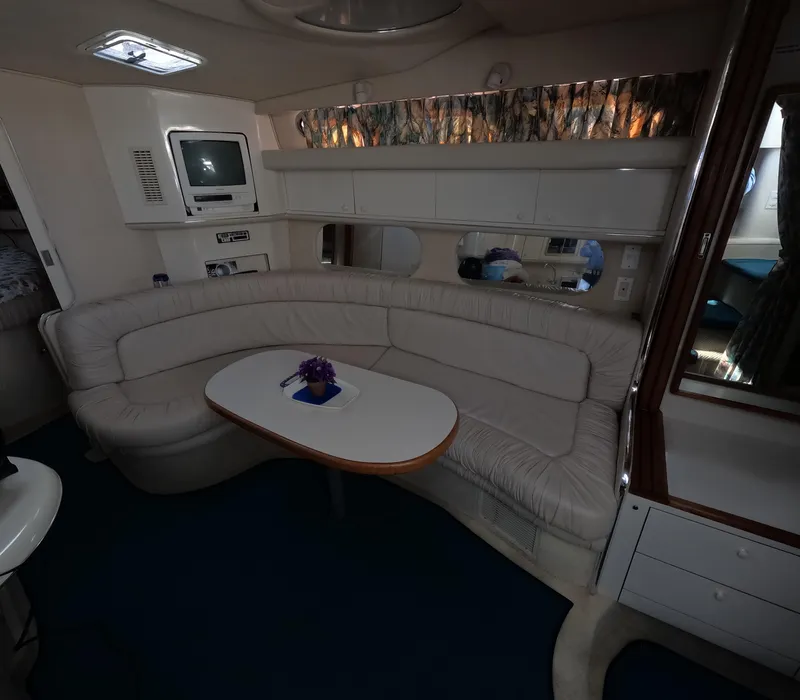 Slide: The Image of Interior of 1995 Sea Ray 370 Sundancer with curved seating and table. - 23