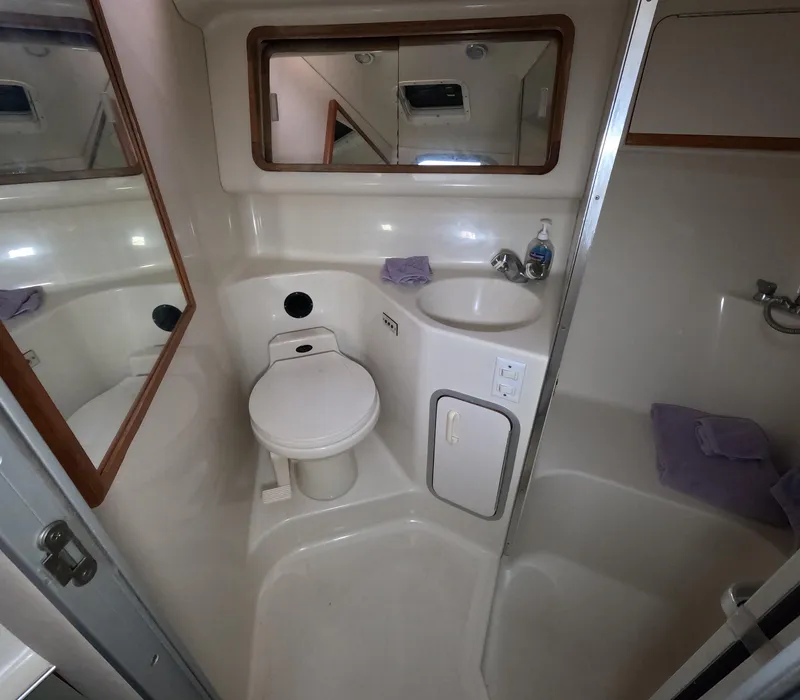 Slide: The Image of Bathroom interior of 1995 Sea Ray 370 Sundancer yacht with toilet, sink, and mirror. - 27