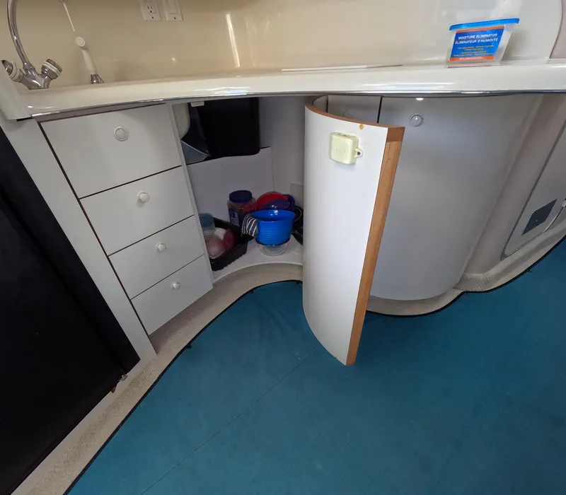 Slide: The Image of 1995 Sea Ray 370 Sundancer kitchen area with open cabinet and blue carpet. - 35